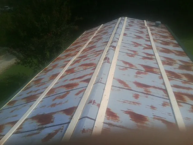 Rusted metal roof panels with new wood purlins before replacement — Storm Damage Roof Repair in Placida by Roofing Brothers